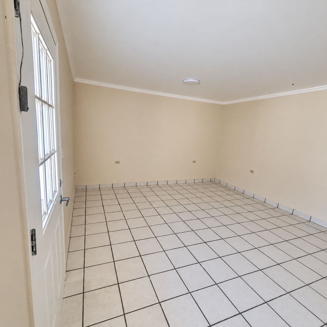 Estancia vacía con puerta acristalada y piso cerámico.